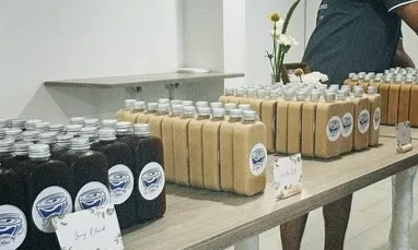 Close view of bottled long blacks and lattes with Brewprint logo stickers